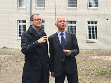 Justizsenator Martin Günthner (links) und Carsten Bauer mit dem Neubau im Hintergrund