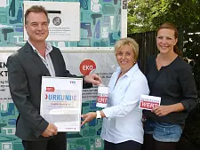 Symbolische Übergabe vor dem prämierten Elektrocontainer (von links nach rechts): Dr. Jens Rösler, Leiter der kommunalen Abfallwirtschaft Bremen beim Senator für Umwelt, Bau und Verkehr, Petra Wulf-Lengner (Innere Mission) und die Projektkoordinatorin des „Fairkaufhaus“ Ulrike Busse