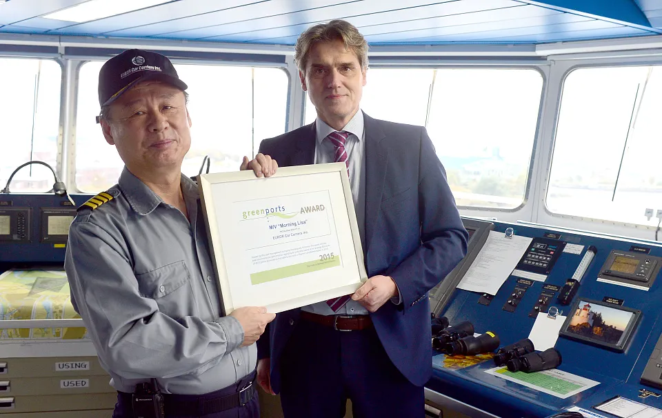 Auf der Brücke: Kapitän Gyeong Sig Lee nimmt die Auszeichnung von bremenports-Geschäftsführer Robert Howe entgegen.