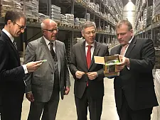Wirtschaftssenator Martin Günthner, Firmeninhaber Heinz Fiege, Bürgermeister Dr. Carsten Sieling und Niederlassungsleiter Frank Breth nehmen eines der vielen Produkte in Augenschein, deren Logistik und Transport Fiege organisiert.