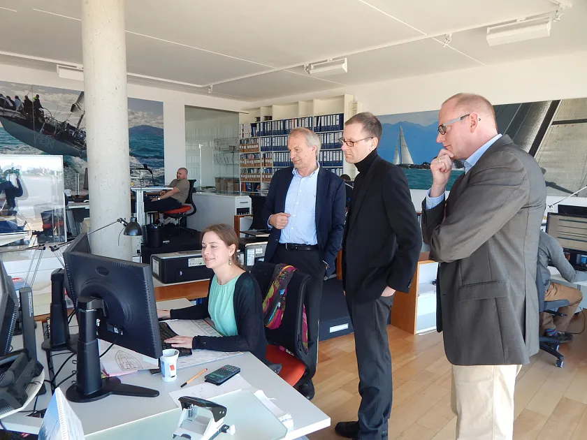 Martin Günthner, Senator für Wirtschaft, Arbeit und Häfen (2. von rechts), lässt sich zusammen mit Nils Schnorrenberger, Geschäftsführer der BIS Bremerhavener Gesellschaft für Investitionsförderung und Stadtentwicklung mbH (rechts), von Torsten Conradi, geschäftsführender Gesellschafter der judel/vrolijk & co. engineering GmbH (3. von rechts), und einer Mitarbeiterin die Konstruktion eines Schiffes erklären