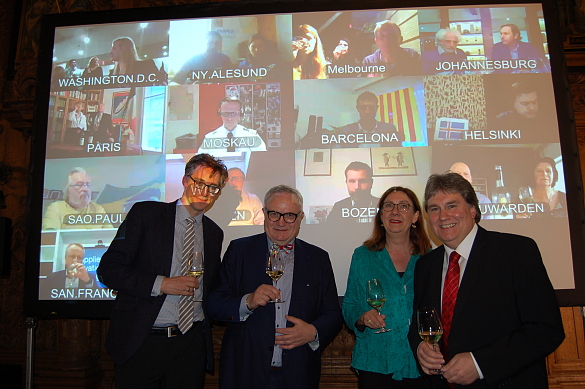 Bürgermeisterin Karoline Linnert mit den Organisatoren der Weinprobe vor der Videoleinwand mit den weltweit vernetzten Weintestern