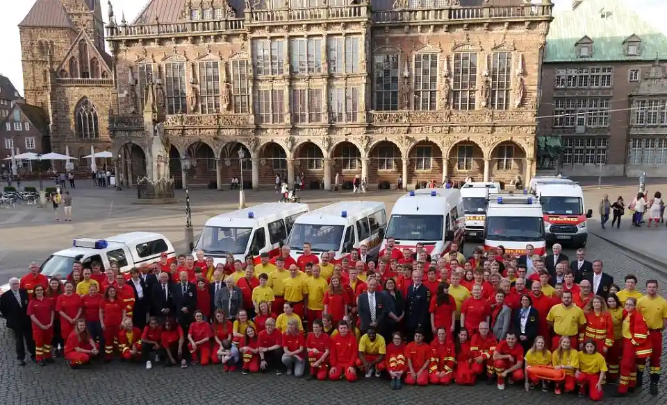 Rund 150 Ehrenamtliche von der Deutschen Lebens-Rettungs-Gesellschaft (DLRG) nehmen Aufstellung vor dem Bremer Rathaus, unter ihnen Sportsenatorin Anja Stahmann (Bildmitte), Karl-Heinz Knorr, Leiter der Feuerwehr in Bremen (im Bild rechts von der Senatorin) und Martin Reincke, Präsident im DLRG-Landesverband Bremen e.V.  (im Bild links von der Senatorin) 