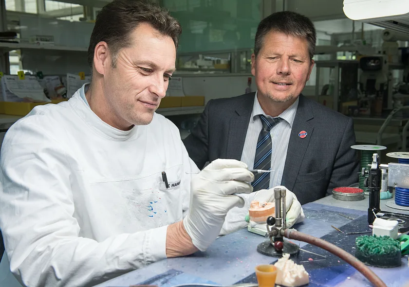 Am ersten Tag seiner Tour schaut Umweltsenator Lohse einem Mitarbeiter des Rübeling Dental-Labors bei der Arbeit über die Schulter.