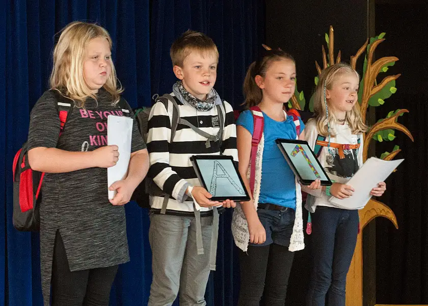 Drittklässler zeigen während eines Theaterstücks ihr Können im Umgang mit dem Tablet.