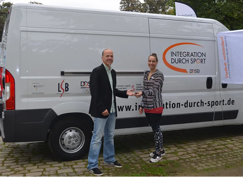 Das Bild zeigt Sportamtsleiter Christian Zeyfang am gestrigen Sonntag am Rande des Laufs  zur Venus  am Markusbrunnen im Bürgerpark, der das Fahrzeug im Namen der Senatorin an Anne-Kathrin Laufmann übergeben hat, die im Präsidium des Landessportbundes für das Thema soziale Arbeit zuständig ist.