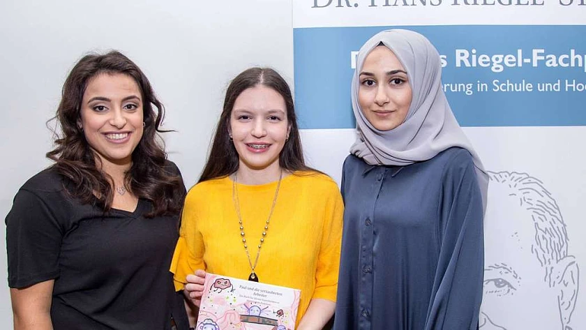 Gizem Vural (v.l.), Selda Güdük und Gizem Görme vom Schulzentrum Walle mit ihrem ausgezeichneten Kinderbuch zur Krankheit „Chorea Huntington“. Foto: Matej/ Uni Bremen