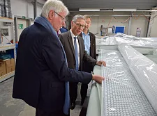 Stefan Lehnert zeigt Bürgermeister Sieling eine der fertigen Dachfolien