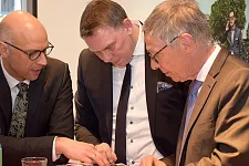 Jan-Peter Halves (links), Geschäftsführer der City Initiative und Jens Ristedt, Geschäftsführer und Inhaber der Ristedt City Modehaus GmbH, zeigen Bürgermeister Carsten Sieling die Broschüre zum "Bremer Kranballett"