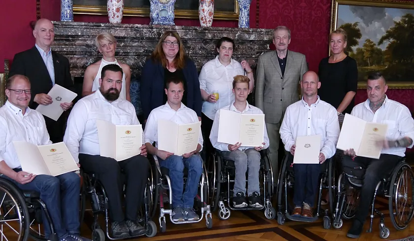 Senatorin Anja Stahmann im Kreis der  „Weserstars Sledge Eishockey“-Mannschaft