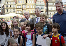 Marco Bode (Aufsichtsratsvorsitzender Werder Bremen), Bürgermeister Carsten Sieling und Bürgerschaftspräsident Christian Weber (v.re.) mit Kindern einer 4. Klassen der Grundschule St. Magnus