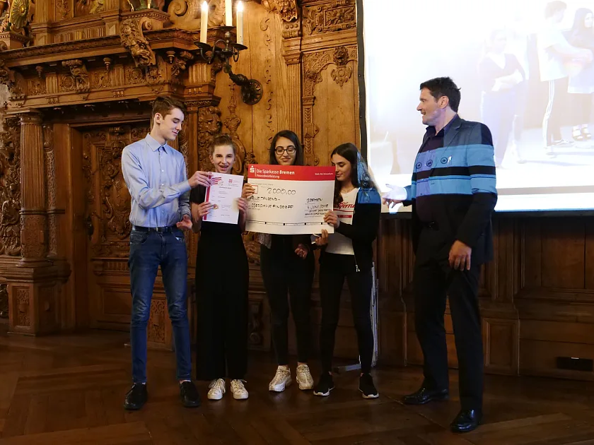 Staatstrat Frank Pietrzok (r.) und das Siegerteam für den Senatspreis: Die Oberschule Findorff 