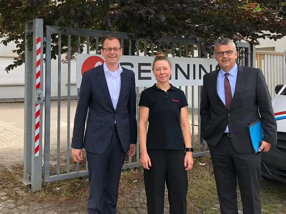 Martin Günthner, Senator für Wirtschaft, Arbeit und Häfen, Annette Bengs, Geschäftsführerin Christian Senning Verpackungsmaschinen GmbH & Co. KG und Andreas Heyer, WFB Wirtschaftsförderung Bremen GmbH vor dem Sitz des Unternehmens in Bremen-Oslebshausen