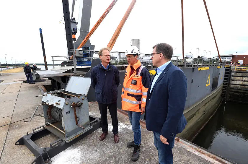 Staatsrat Jörg Schulz an der Oslebshauser Schleuse mit den bremenports Mitarbeitern Henry Behrends (rechts) und Lutz Jankowsky (Mitte)