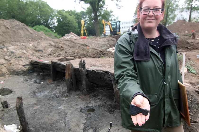 Archäologin Julia Schmidt mit einer Miniaturaxt aus dem 13. Jahrhundert