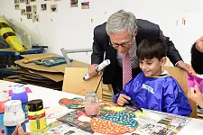 Mert vom Kinderatelier Roter Hahn zeigt Bürgermeister Sieling sein Kunstwerk