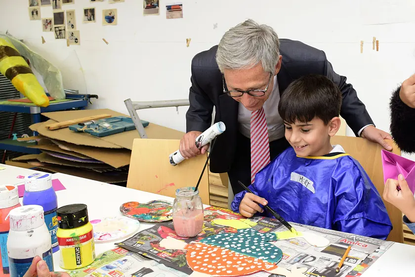 Mert vom Kinderatelier Roter Hahn zeigt Bürgermeister Sieling sein Kunstwerk