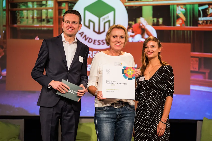 Preisverleihung in der UFA-Fabrik in Berlin: Sebastian Gallander, Geschäftsführer der nebenan.de-Stiftung, mit Heike Binne vom Haus der Zukunft in Lüssum und Lena Rickenberg von der nebenan.de-Stiftung (v.l.n.r).