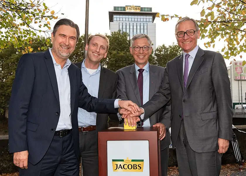 Zurück an der Weser: Luc Van Gorp und Andreas Windler freuen sich zusammen mit  Bürgermeister Dr. Carsten Sieling  und Dr. Johann Christian Jacobs über den wieder leuchtenden Jacobs-Schriftzug auf dem ehemaligen Röstturm der Jacobs-Kaffeerösterei und heutigem Sitz von JDE Deutschland (v.l.) |Foto: JDE