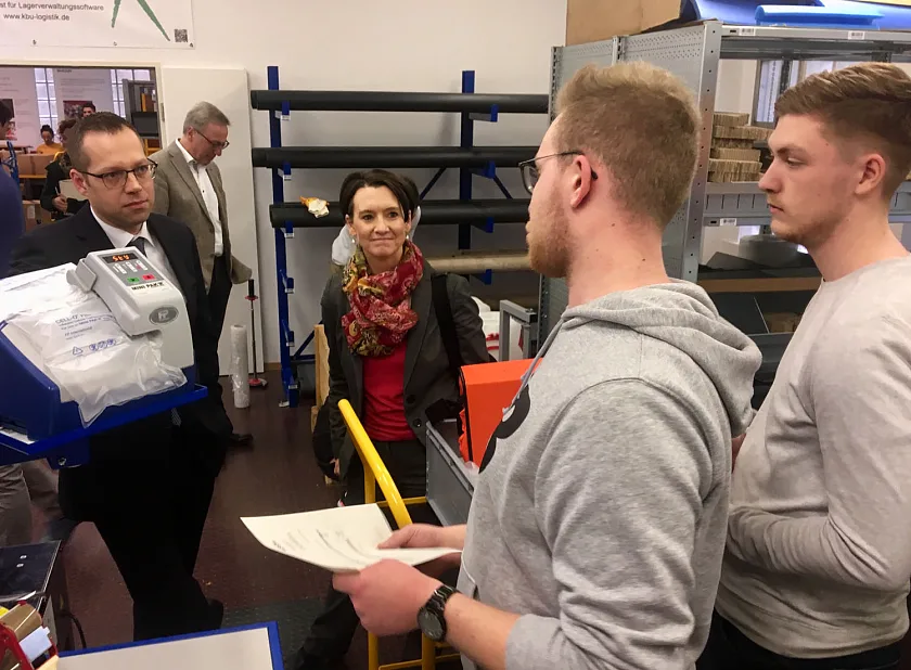 Informationen aus erster Hand (v.l) Schulleiter Robbin Hagen und Senatorin Claudia Bogedan lassen sich von den Auszubildenden Justin Jürgens und Merlin Boss einen Arbeitsbereich erklären.