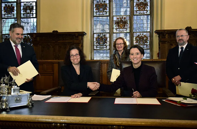 Richelle Budd Caplan (sitzend links) und Senatorin Claudia Bogedan unterzeichnen die Absichtserklärung in der Oberen Rathaushalle; von links stehend: Rogel Rachmann, Gesandter der Botschaft des Staates Israel in Berlin, Elvira Noa, Vorsitzende der Jüdischen Gemeinde Bremen und Udo Michallik, Generalsekretär der Kultusministerkonferenz 
