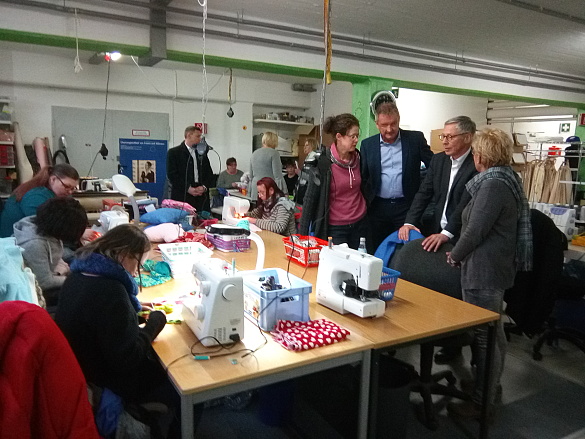In der Schneiderei des alz informiert sich Carsten Sieling im Gespräch mit den Beschäftigten über das Textilrecycling