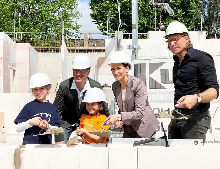 Zeitkapsel gekonnt einzementiert. Gemeinsam mit zwei Grundschülerinnen griffen Senatorin Claudia Bogedan, Schulleiter Karl-Holger Meyer (hinten links) und Architekt Hans Müller-Hirschmann zur jeweiligen Maurerkelle. 