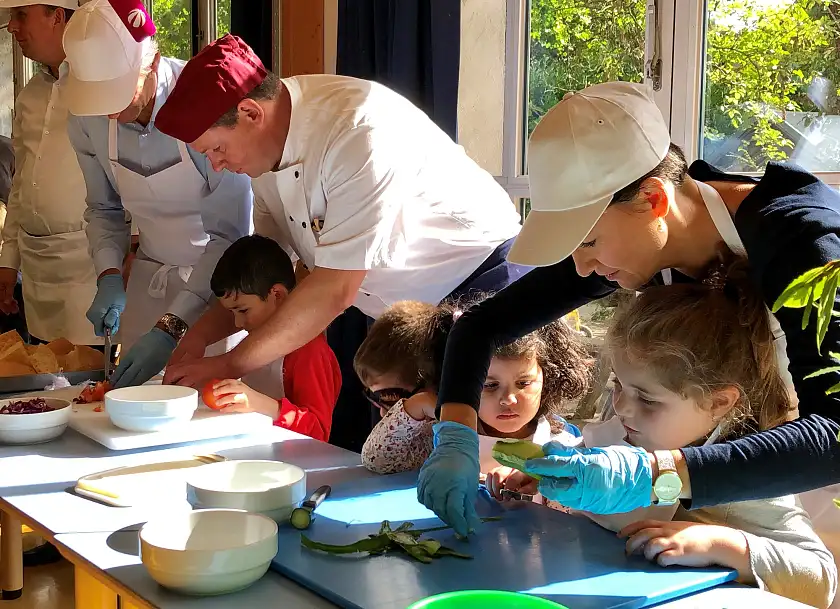 Senatorin Bogedan schnibbelt  gemeinsam mit den Kindern der Kita  Aller Park ein leckeres Rezept aus dem KiTa-Kochbuch.