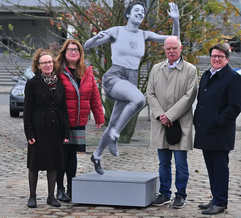 Gemeinsam eröffneten sie die Ausstellung „Zwischen Erfolg und Verfolgung – Jüdische Stars im deutschen Sport bis 1933 und danach“: Elvira Noa, Senatorin Anja Stahmann, Professor Dr. Lorenz Peiffer und Dr. Hubertus Hess-Grunewald vor einem Bildnis der Sportlerin Gretel Bergmann. Bergmann gehörte zu den besten Hochspringerinnen in Deutschland, wurde aber auf Grund ihrer jüdischen Herkunft nicht für die Olympischen Sommerspiele 1936 nominiert, nachdem sie bereits 1933 von ihrem Sportverein ausgeschlossen worden war. Sie emigrierte in die USA, nahm noch zu Kriegszeiten die US-amerikanische Staatsbürgerschaft an. 