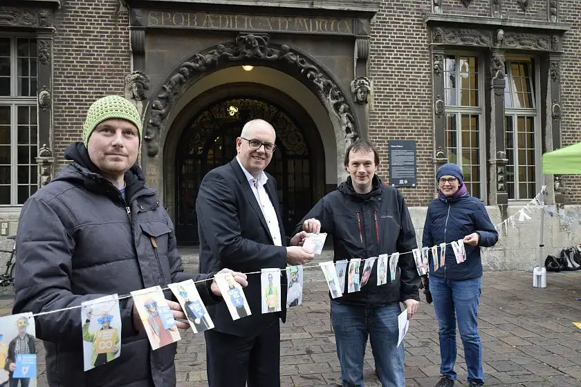 BeN-Geschäftsführer Christopher Duis (2.v.r.) zeigt Bürgermeister Bovenschulte einige Exemplare der gesammelten Postkarten