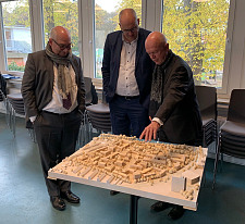 Besuch Stiftungsdorf Ellener Hof: Bürgermeister Andreas Bovenschulte mit André Vater und Alexander Künzel vor dem Modell des Bauvorhabens