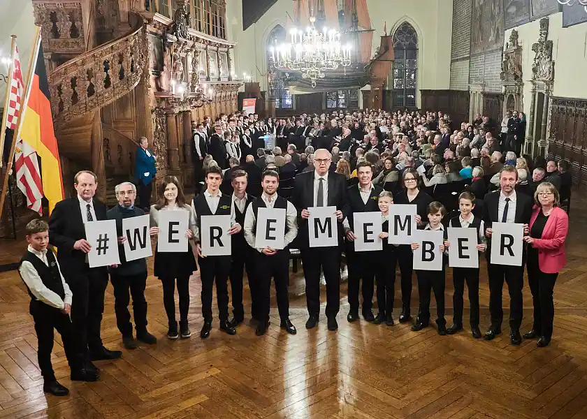 Frank Bajohr (v.l.), Grigori Pantijelew (Jüdische Gemeinde), Bürgermeister Andreas Bovenschulte, Thomas Köcher (Landeszentrale für pol. Bildung) und Martina Höhns (Senatskanzlei) mit Mitgliedern des Chores und Schülerinnen der Oberschule Findorff