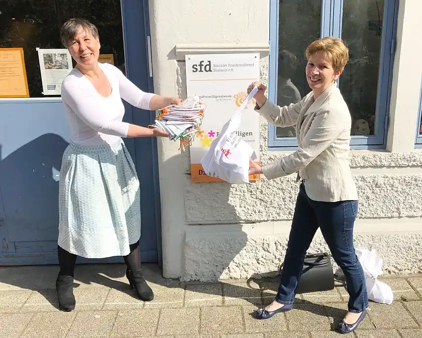 Kontaktlose Übergabe der JVA-Stoffmasken: Senatorin Claudia Schilling (r.) und Claudia Fantz von der Freiwilligenagentur Bremen