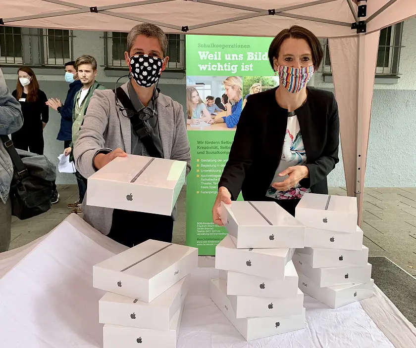 Senatorin Claudia Bogedan (rechts) und Personalrätin Angelika Hanauer verteilen Tablets an der Grundschule Oderstraße.