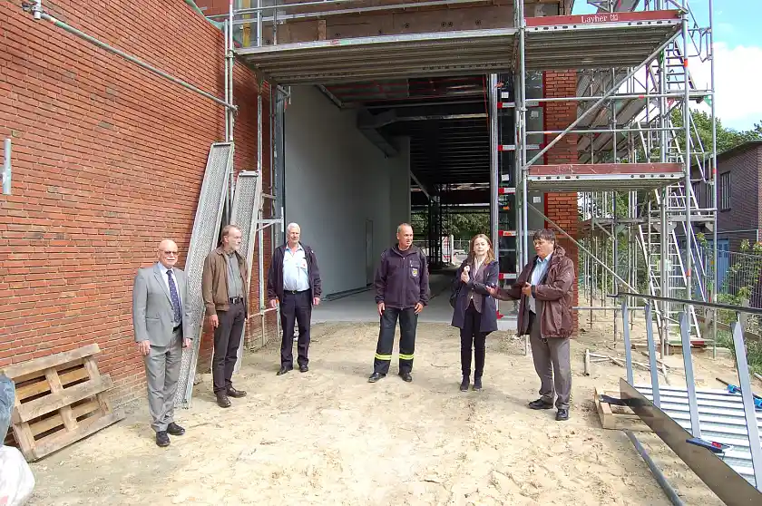 Innensenator Ulrich Mäurer (v.l.n.r.), der Architekt Ulrich Ruwe, der Wehrführer der Freiwilligen Feuerwehr Farge Holger Morisse, der Verantwortliche für die Bauvorhaben bei der Feuerwehr Bremen Ulrich Fincke, die Geschäftsführerin von Immobilien Bremen Susanne  Kirchmannn und der Finanzsenator Dietmar Strehl vor der Durchfahrt zum Hinterhof des Neubaus der Freiwilligen Feuerwehr Farge