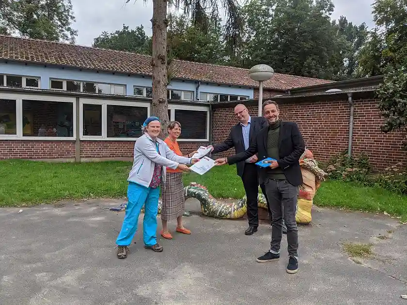Tarek Bauer (vorne rechts), die Direktorin der Schule Ulrike Weiß (hinten links), die Lehrerin Carola Hartich (vorne links) und Olaf Joachim (hinten rechts) bei der Übergabe des Methodenhandbuches an die Vertreterinnen von "Eine Welt in der Schule / Grundschulverband e.V." 