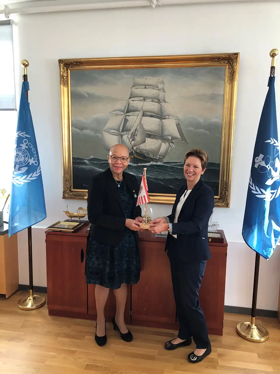 Senatorin Dr. Schilling (rechts) überreicht der Universitäts-Präsidentin Dr. Doumbia-Henry die Speckflagge