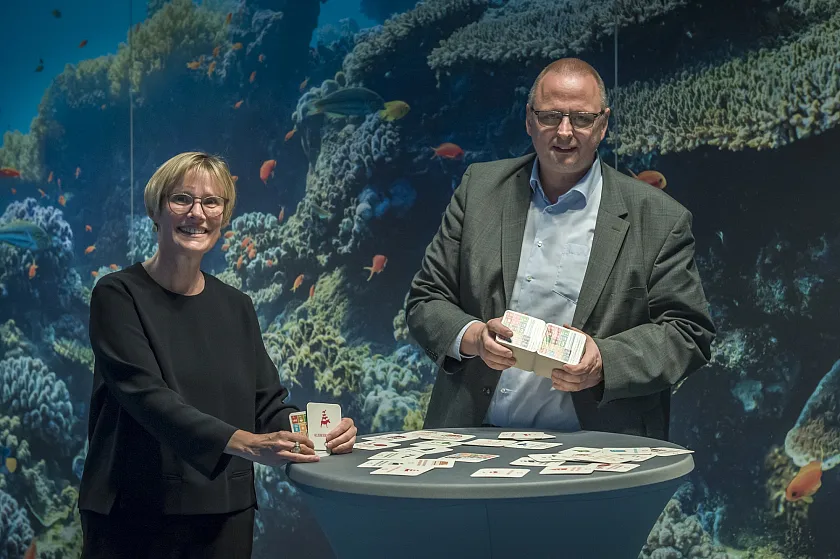 Dr. Olaf Joachim überreicht Gabriele Müller die  "Bierdeckel auf Bremisch"  (Foto: Überseemuseum)