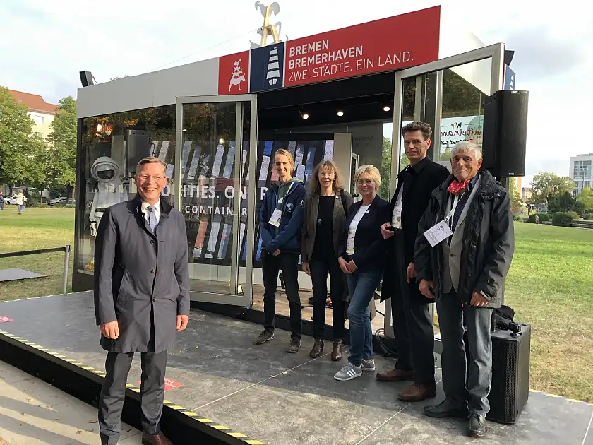 Bürgerschaftspräsident Imhoff (li.) mit der Bürgerdelegation am Präsentations-Kubus der Freien Hansestadt Bremen, der für einen Monat am Platz-der-Einheit im Herzen Potsdams stand (v.l.): Jonas Ehlers, Heidrun Pörtner, Ingrid Kirschenlohr, Marcus Henke und Horst Wolfrum
