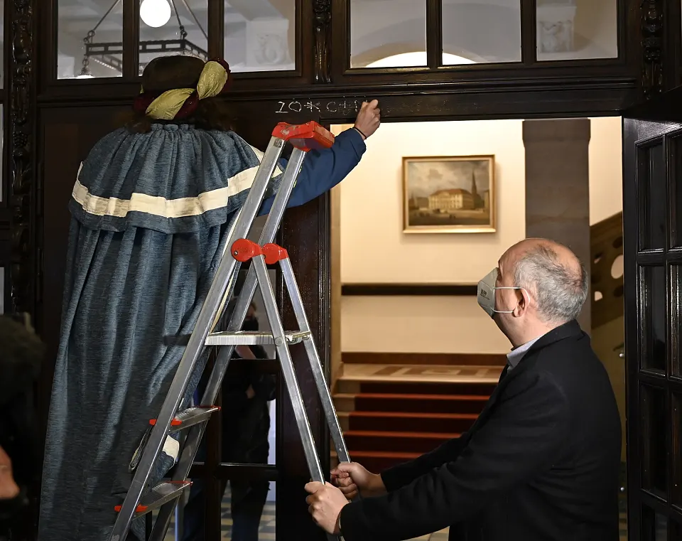 Bild Sternsinger schreibt mit Kreide den Segenwunsch an die Eingangstür