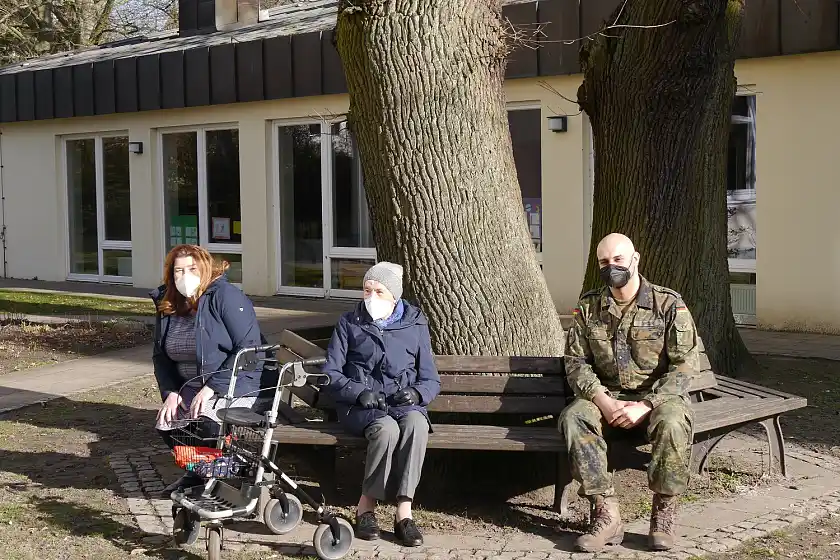 (v.l.n.r.) Senatorin Anja Stahmann, Bewohnerin Elisabeth Frenz (92) und Stabsunteroffizier Angelo Srour vor dem Eingang der Caritas-Pflegeeinrichtung St. Elisabeth Foto: Pressestelle Senatorin für Soziales, Jugend, Integration und Sport