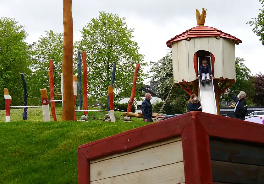 Huchtings Ortsamtsleiter Christian Schlesselmann, Sozialsenatorin Anja Stahmann und Holger Witzig (GOFUS e.V; v.l.n.r.) beobachten die erste Rutschpartie des kleinen Sergio (7) auf dem neueröffneten Spieltplatz  