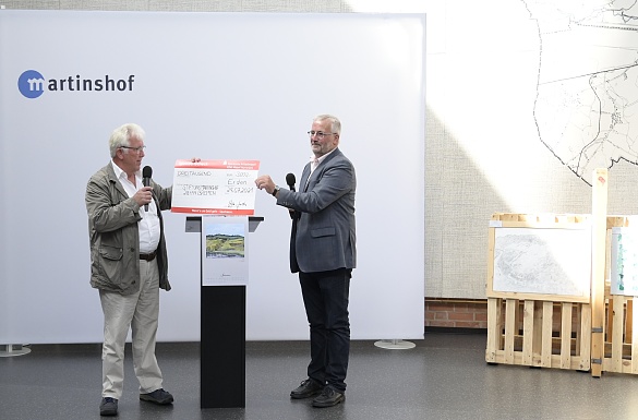 Scheckübergabe mit Winzer Stefan Justen und Wilfried Hautop von der Stiftung Martinshof (v.r.) Foto: Senatspressestelle