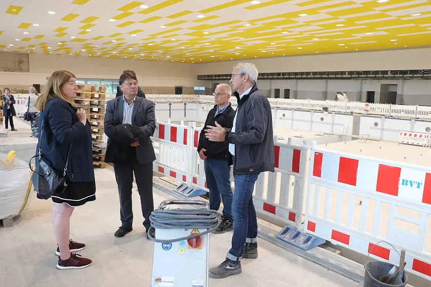 Architekt Udo Janßen (r) und Bauleiter Uwe Siefke (2. v.r.) erläutern Sportsenatorin Anja Stahmann und Finanzsenator Dietmar Strehl den Baufortschritt.