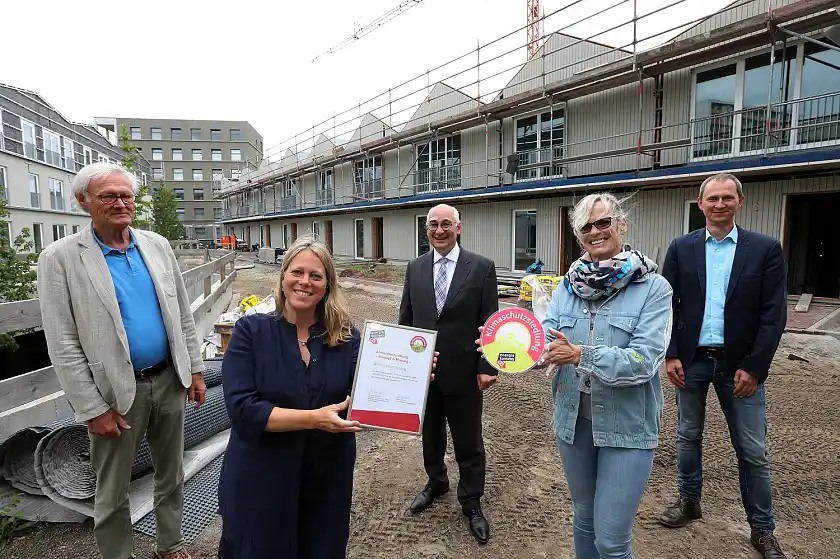 Offiziell ausgezeichnet: Das Neubauquartier Ellener Hof erhält das Siegel "Klimaschutzsiedlung" .(v.l.n.r.) Edo Lübbing von Gaertner, Beauftragter für Ökologie und Holzbau der Bremer Heimstiftung, Senatorin Maike Schaefer, André Vater, Vorstandsvorsitzender der Bremer Heimstiftung, Sabine Schöbel, Leiterin des Stiftungsdorfes Ellener Hof und Koordinatorin des Stadtleben Ellener Hof, Martin Grocholl, Geschäftsführer der Klimaschutzagentur energiekonsens. Foto: Bremer Heimstiftung, Fotograf: Martin Rospek)