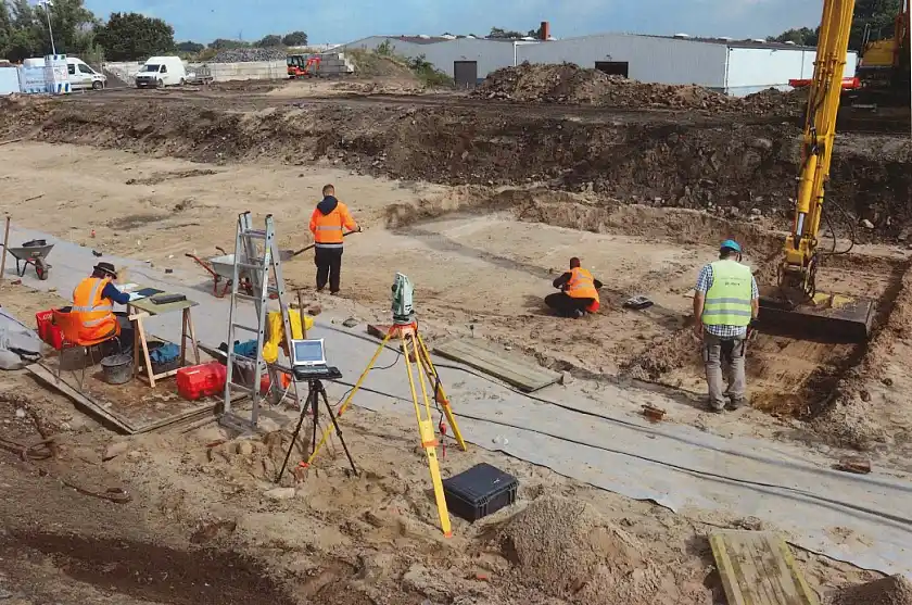 Blick auf die Grabungsstelle, im Bild auch ukrainische Studierende, die  mit großer Akribie und großem Gerät an der Arbeit sind. Foto: Landesarchäologie Bremen, J. Geidner