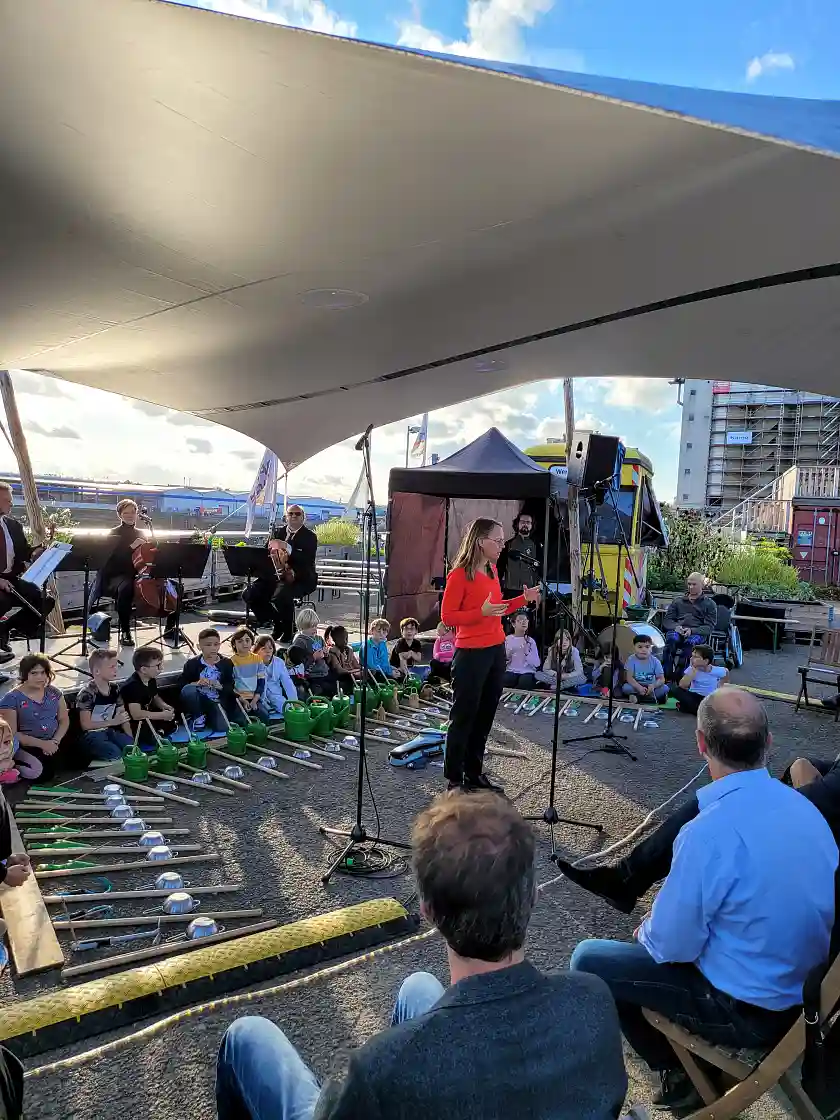 Musikinstrumente aus Gießkannen, Hacken und anderem Gartenwerkzeug: Kinder- und Bildungssenatorin Sascha Aulepp beim Besuch der Grundschule Überseestadt, die parallel mit der Gemüsewerft und den Bremer Philharmonikern kooperiert.. Foto: SKB