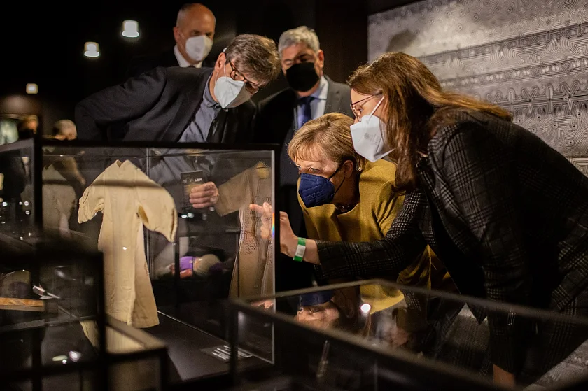 Bundeskanzlerin Angela Merkel (2. v.r.) lässt sich im Deutschen Auswandererhaus von dessen geschäftsführender Direktorin Dr. Simone Blaschka (rechts) ein Exponat erläutern. Foto: Tim David Müller-Zitzke