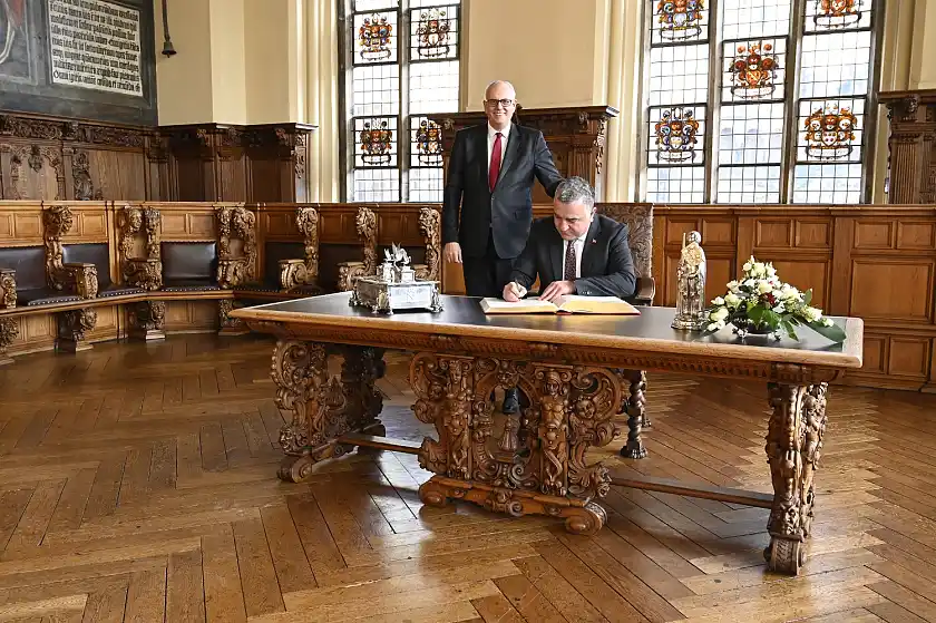 Der türkische Botschafter Ahmet Başar Şen (sitzend) und Bürgermeister Dr. Andreas Bovenschulte beim Eintrag in das Goldene Buch ein. Foto: Senatspressestelle