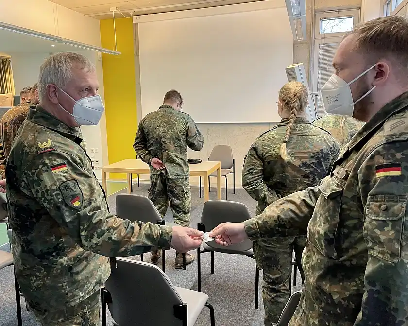 General Andreas Henne (links) überreicht den Soldatinnen und Soldaten im Gesundheitsamt einen Coin des Kommandos Territoriale Aufgaben. Inschrift: "Dank und Anerkennung - Hilfeleistung Corona". Foto: Bundeswehr/Krey 